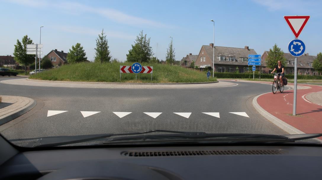 Fietser in de berm langs een weg buiten de bebouwde kom